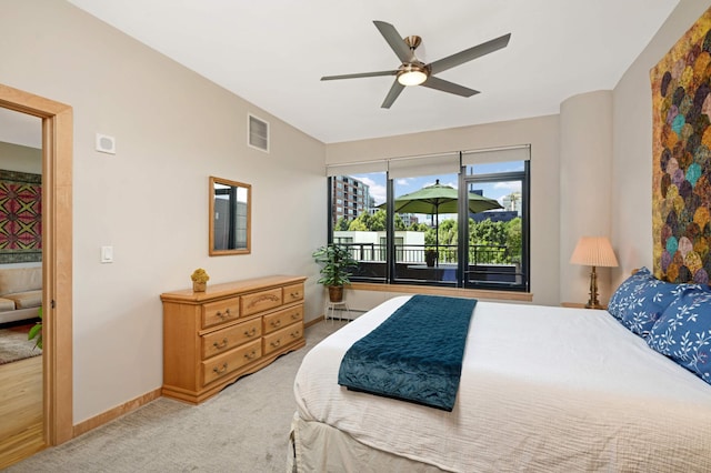 carpeted bedroom featuring a baseboard heating unit and ceiling fan