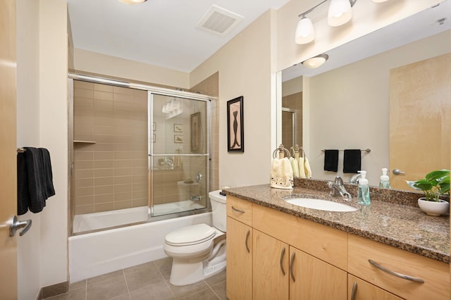 full bathroom featuring toilet, combined bath / shower with glass door, tile patterned floors, and vanity