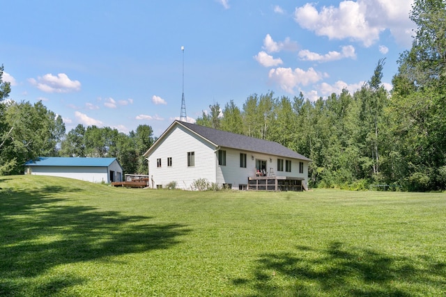 rear view of house featuring a wooden deck and a yard