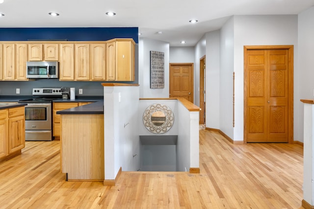 kitchen with stainless steel appliances, recessed lighting, dark countertops, light wood-style floors, and light brown cabinetry
