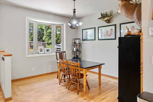dining space with baseboards and light wood-style floors