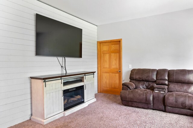 living area with light colored carpet and wood walls