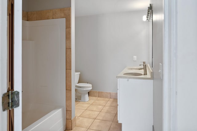bathroom featuring tile patterned floors, toilet, double vanity, and a sink
