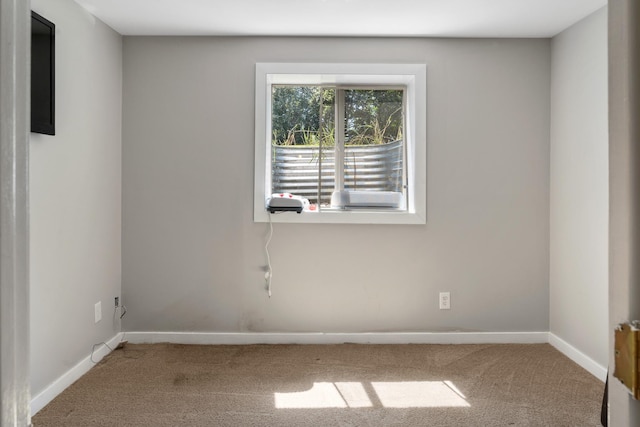 carpeted empty room featuring baseboards