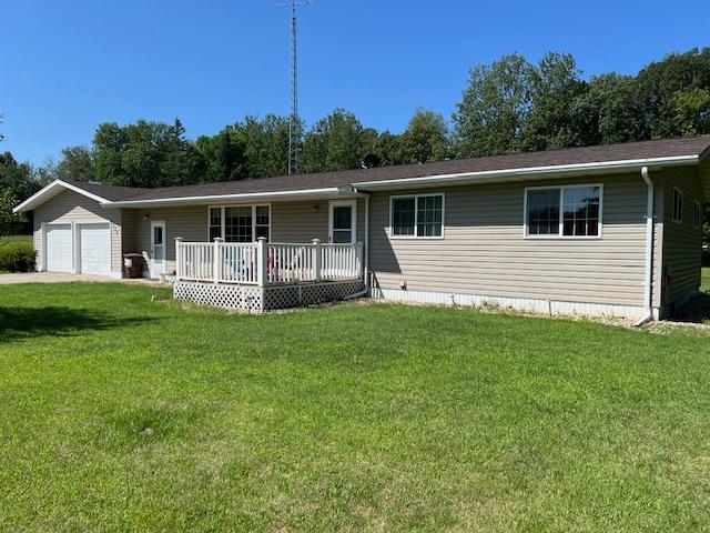 single story home with a garage, a front yard, and a deck