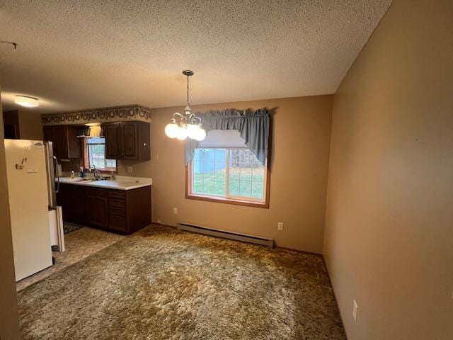 kitchen with a baseboard heating unit, dark brown cabinets, white refrigerator, a textured ceiling, and a chandelier