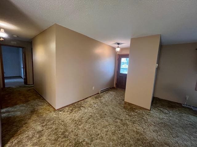 carpeted empty room with a baseboard radiator and a textured ceiling