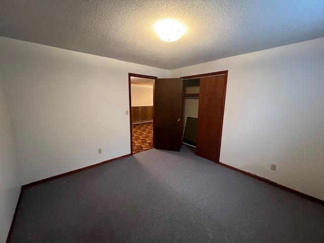 unfurnished bedroom with carpet flooring, a textured ceiling, and a closet