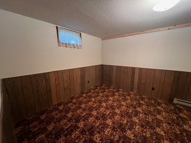 basement with a textured ceiling and wood walls