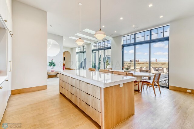 kitchen featuring light wood-type flooring, baseboards, modern cabinets, and light brown cabinetry