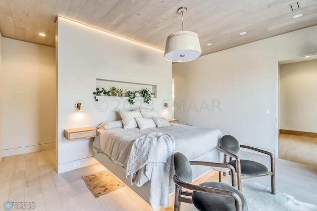 bedroom featuring baseboards, wood ceiling, and wood finished floors