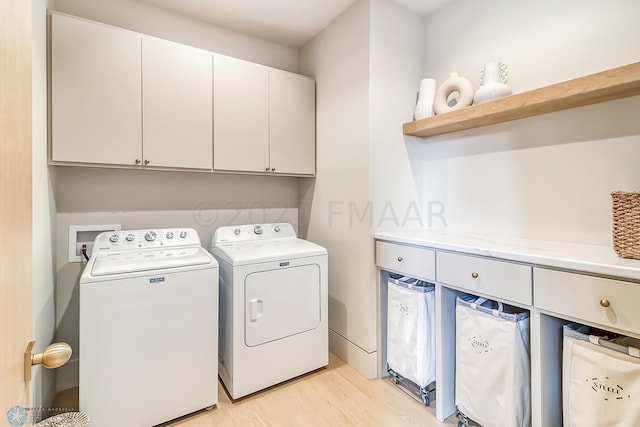 laundry area featuring cabinet space, independent washer and dryer, and light wood-style floors