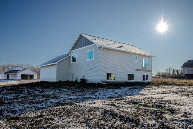 back of house featuring central AC unit and a garage