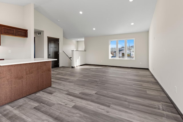 kitchen with high vaulted ceiling and light hardwood / wood-style flooring