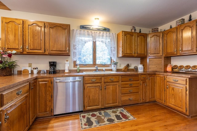 kitchen with sink, light hardwood / wood-style flooring, and stainless steel dishwasher