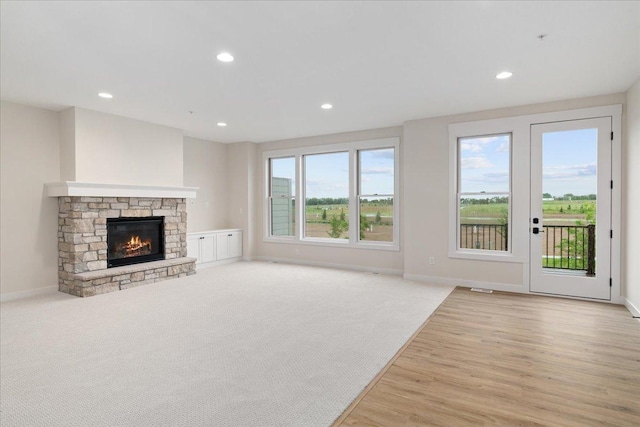 unfurnished living room featuring a fireplace and light carpet