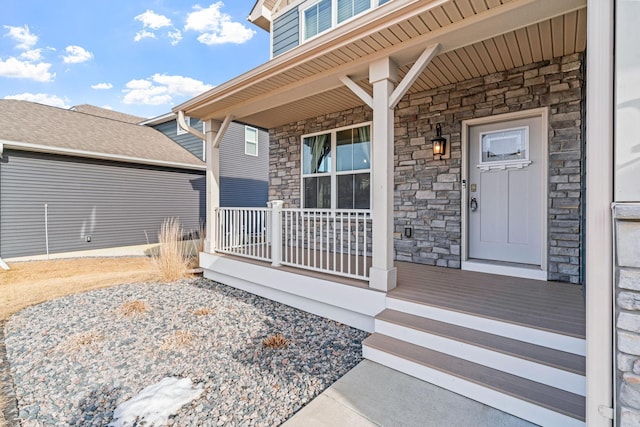 property entrance featuring stone siding and covered porch