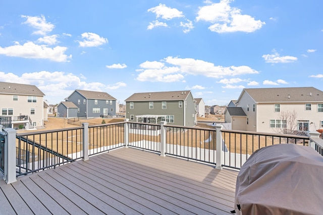 wooden terrace with a residential view and a grill