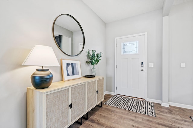 foyer entrance with wood finished floors and baseboards