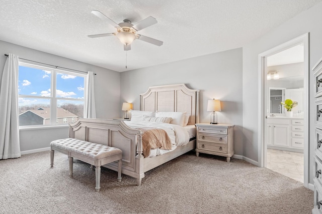 bedroom featuring light carpet, baseboards, connected bathroom, ceiling fan, and a textured ceiling