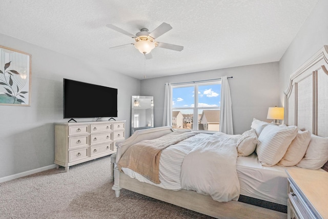 bedroom featuring ceiling fan, a textured ceiling, carpet flooring, and baseboards