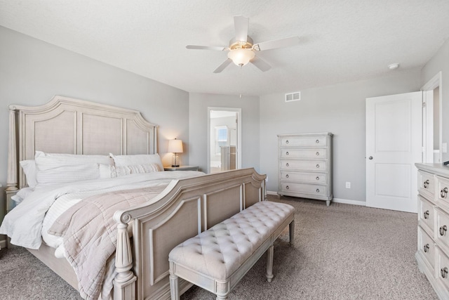 bedroom with ceiling fan, connected bathroom, light carpet, visible vents, and baseboards