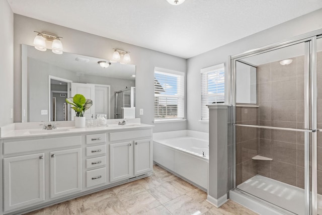 bathroom with double vanity, a sink, a bath, and a shower stall