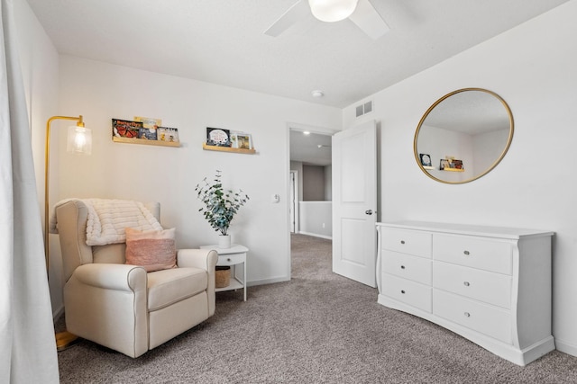 living area with carpet floors, ceiling fan, visible vents, and baseboards