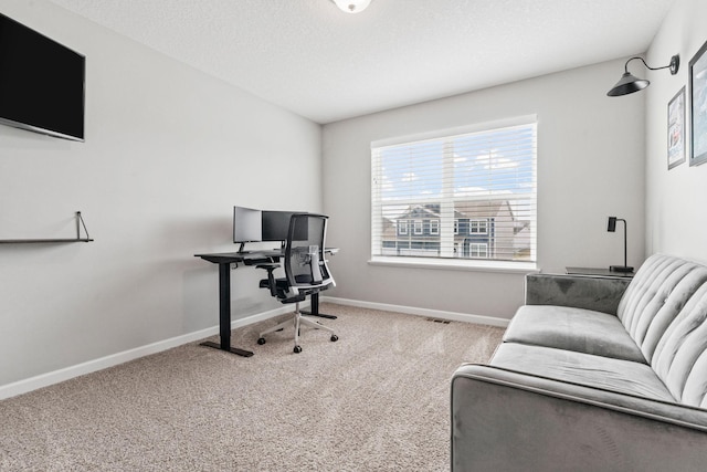 office area with a textured ceiling, carpet, visible vents, and baseboards