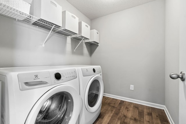 laundry room with a textured ceiling, laundry area, dark wood-style flooring, baseboards, and washer and clothes dryer