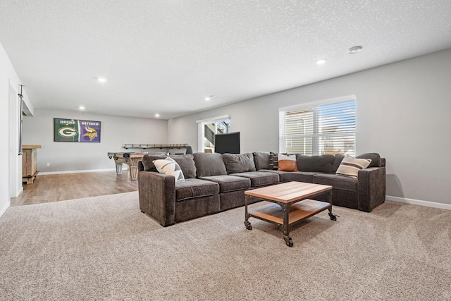 living area featuring recessed lighting, a textured ceiling, baseboards, and wood finished floors