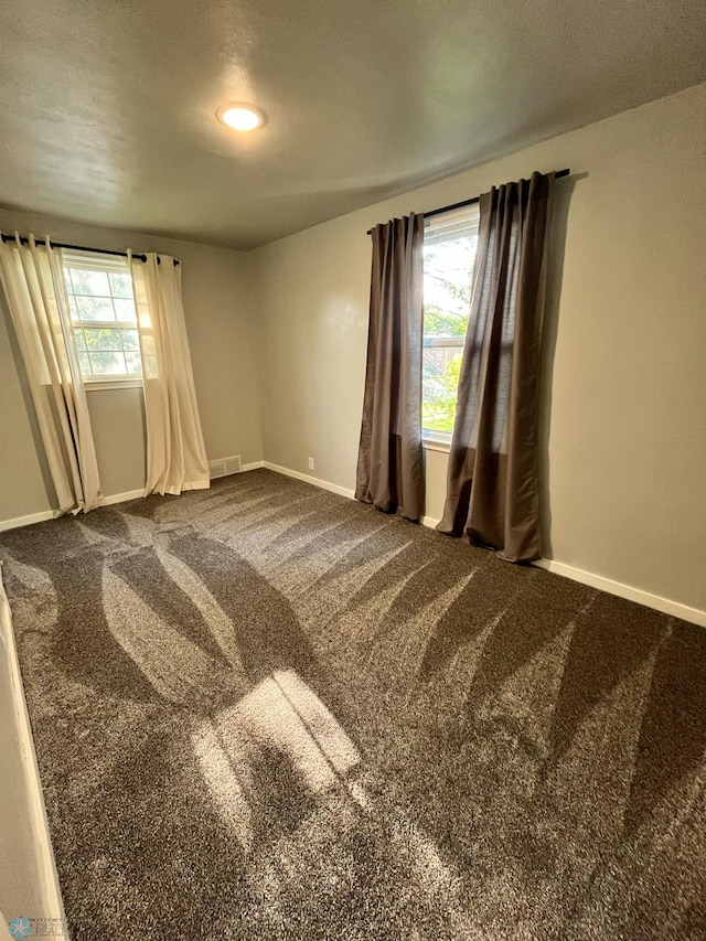 carpeted spare room featuring a textured ceiling