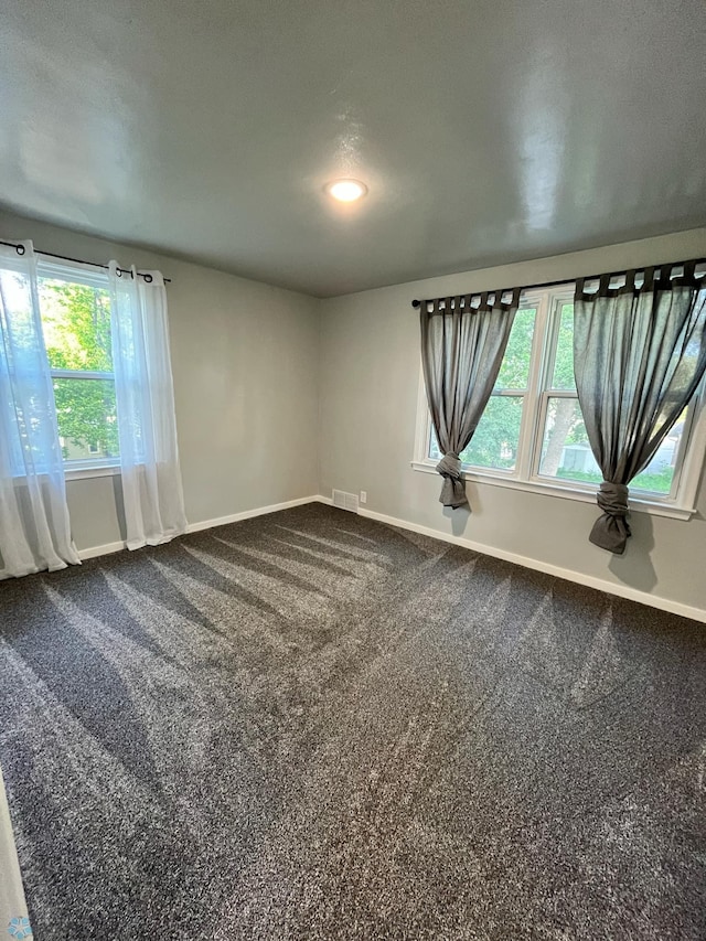 empty room with carpet floors and a textured ceiling