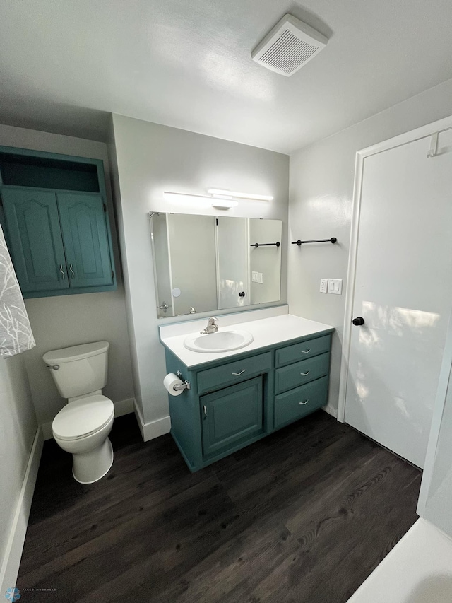 bathroom featuring toilet, vanity, and hardwood / wood-style floors