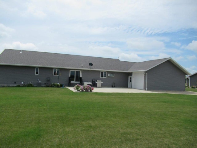 back of house featuring central air condition unit, an attached garage, a patio, and a lawn