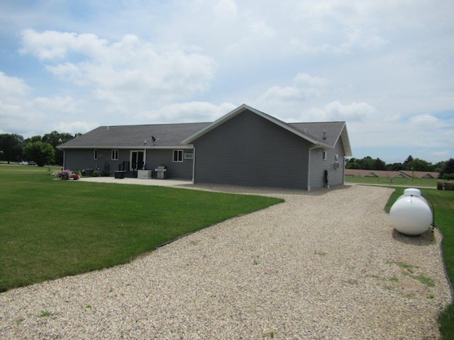 rear view of house featuring a lawn, a patio area, and driveway
