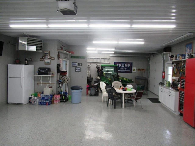 garage with white refrigerator and a garage door opener