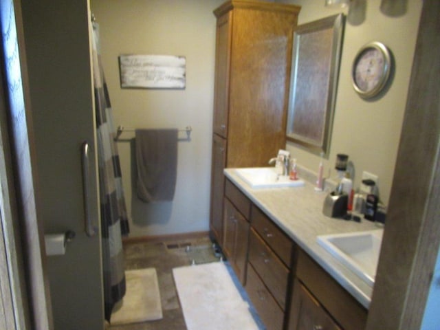 bathroom with a sink, double vanity, and a shower with shower curtain