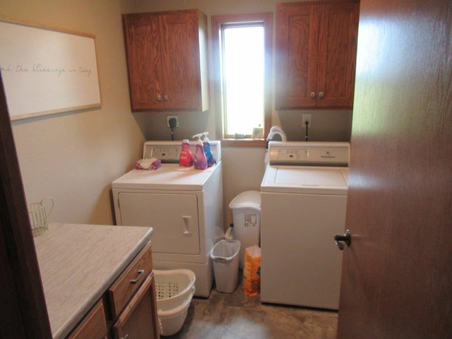 clothes washing area featuring washer and dryer and cabinet space