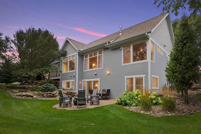 rear view of property with a patio area, a shingled roof, and a yard