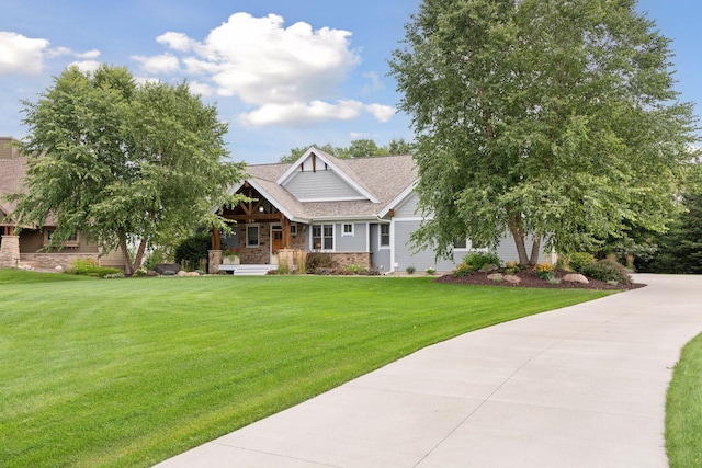 craftsman-style home featuring stone siding, roof with shingles, a porch, and a front lawn