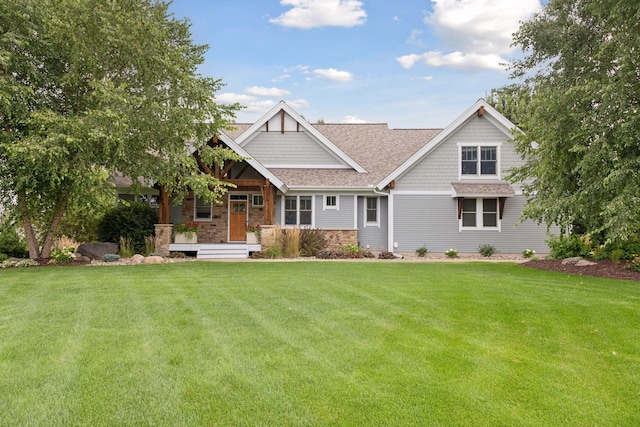 craftsman inspired home featuring stone siding, covered porch, a front yard, and roof with shingles