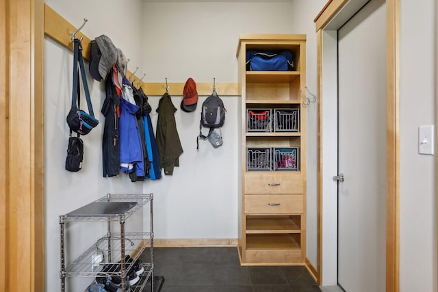 mudroom featuring baseboards and dark tile patterned floors