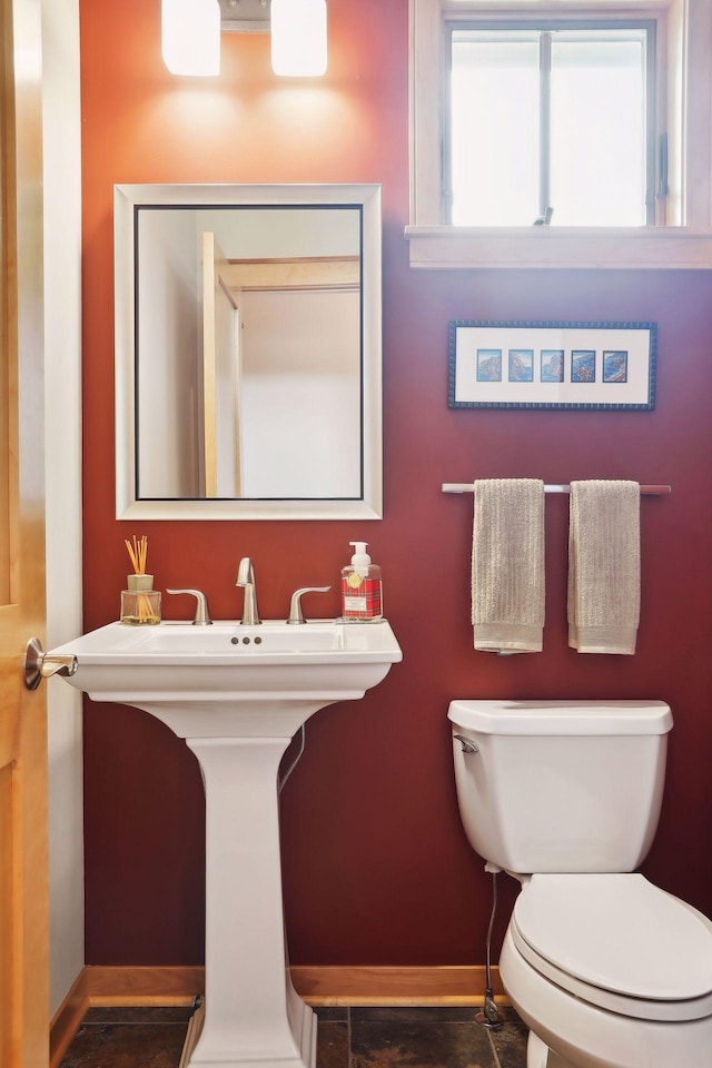 bathroom with toilet, baseboards, and a sink