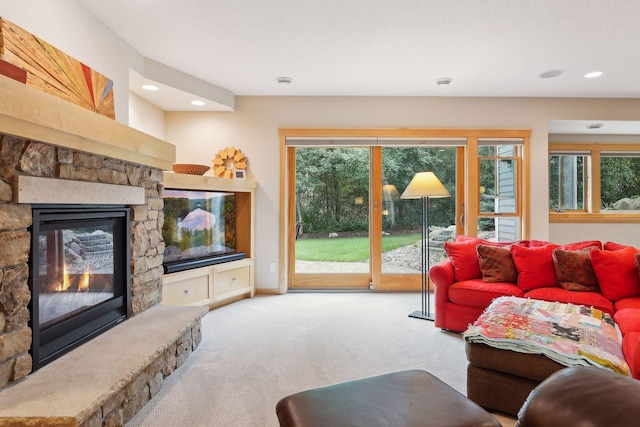 living room featuring recessed lighting, a stone fireplace, carpet flooring, and baseboards