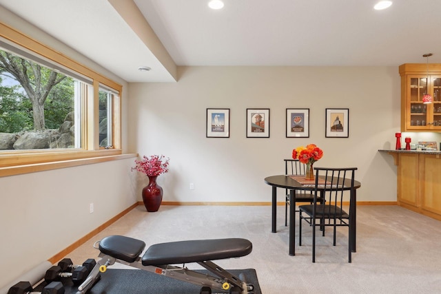 exercise area featuring recessed lighting, baseboards, light colored carpet, and a dry bar