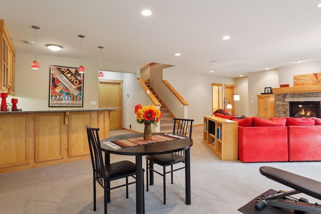 dining space with recessed lighting, stairway, light colored carpet, and a fireplace