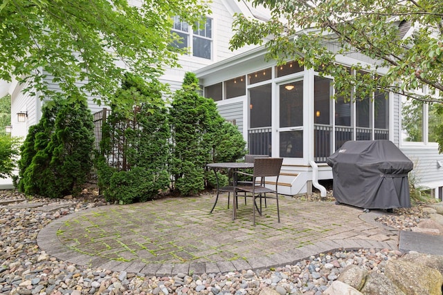 view of patio featuring a sunroom and a grill