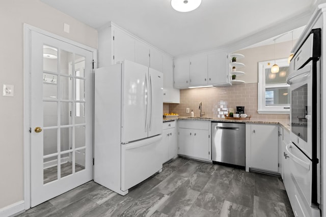 kitchen with backsplash, white appliances, pendant lighting, white cabinets, and sink