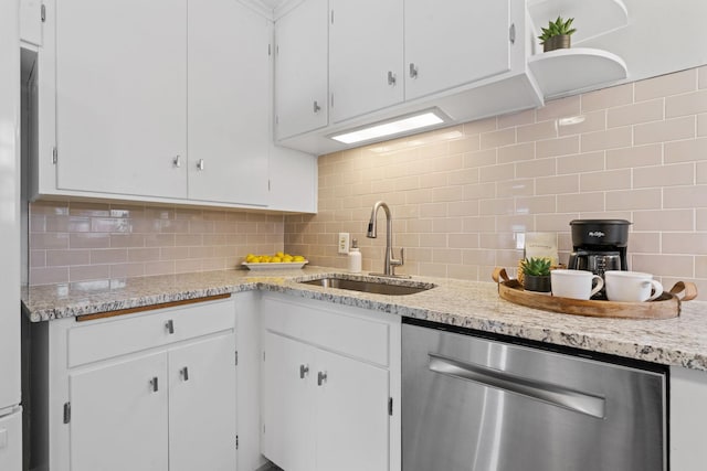 kitchen with stainless steel dishwasher, tasteful backsplash, and white cabinetry